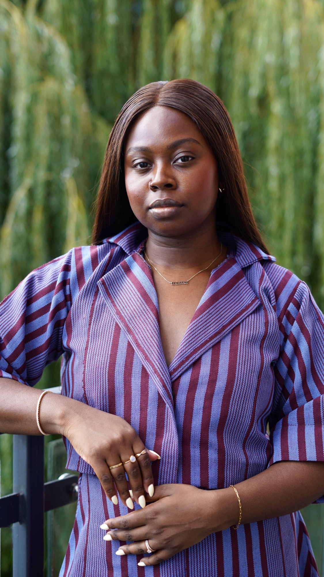 Desola Franklin standing outdoors in front of a willow tree